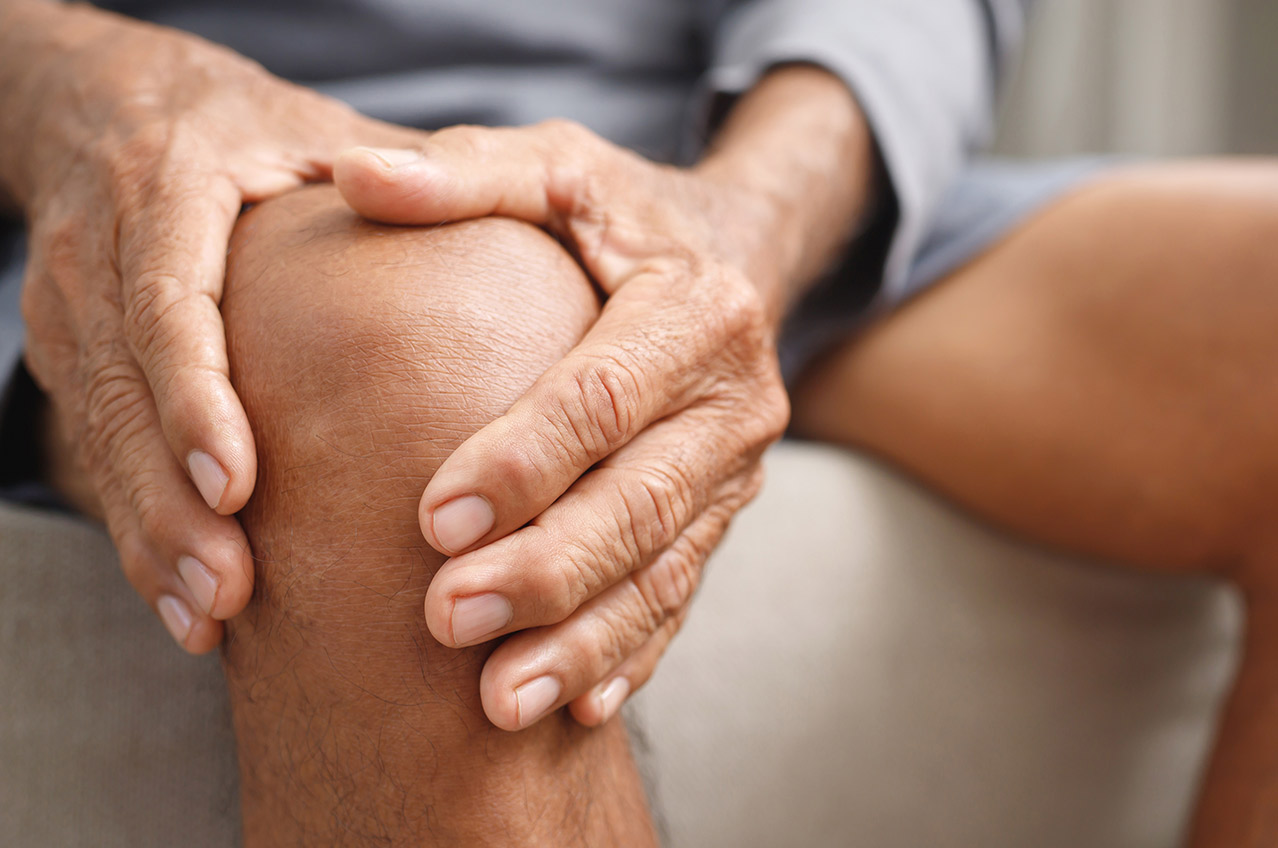 Basale Stimulation hilft bei körperlicher Einschränkung Basale Stimulation - Ein älterer Mensch hält sich das Knie, weil er eingeschränkt ist